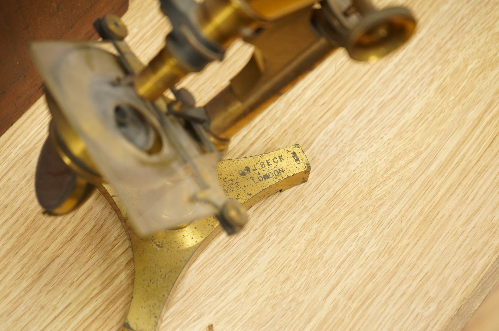 A late 19th century brass compound binocular microscope, by R. & J. Beck, London, number 13654, mahogany cased, together with accessories, including a pair of eye pieces and three objectives. Instrument height 39cm